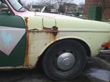 Rust along rear vertical edge of front fender